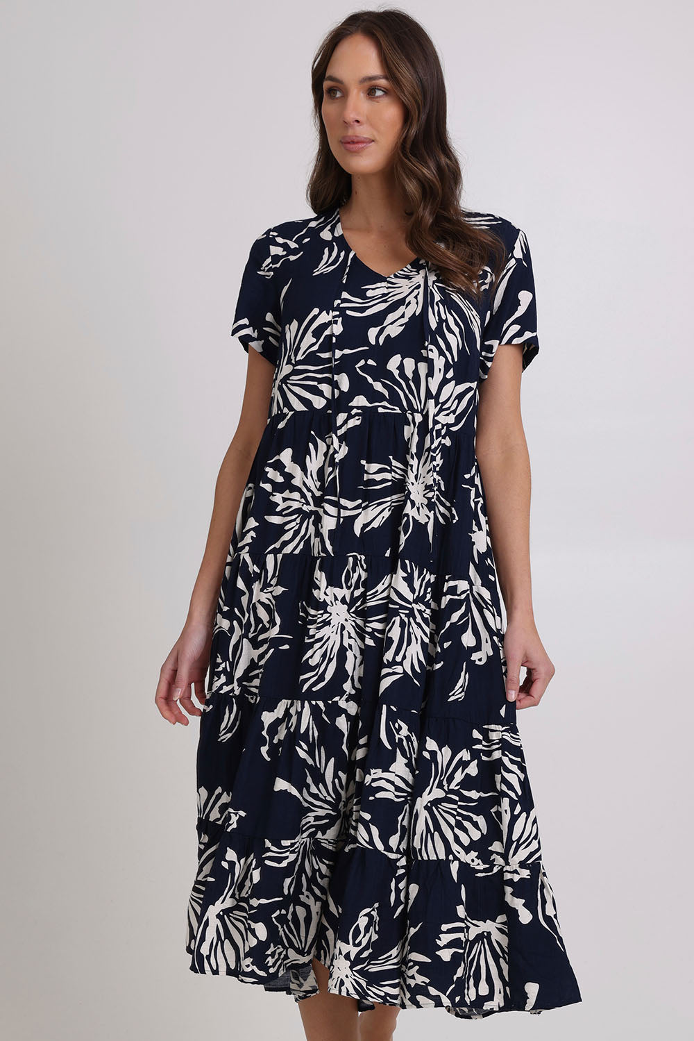 Model Madeline wearing size 10 of the Tier Garden Dress in colour Navy (Blue), from the front, cropped image