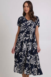 Model Madeline wearing size 10 of the Tier Garden Dress in colour Navy (Blue), from the front, cropped image