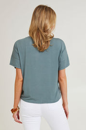 Model Grace wearing size 10 of the Bamboo Twist Top in colour Petrol (Green), from the back