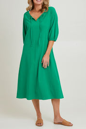 Model Grace wearing size 10 of the Pop Floral Core Cotton Upcycle Dress in colour Green (Green), from the front, cropped image