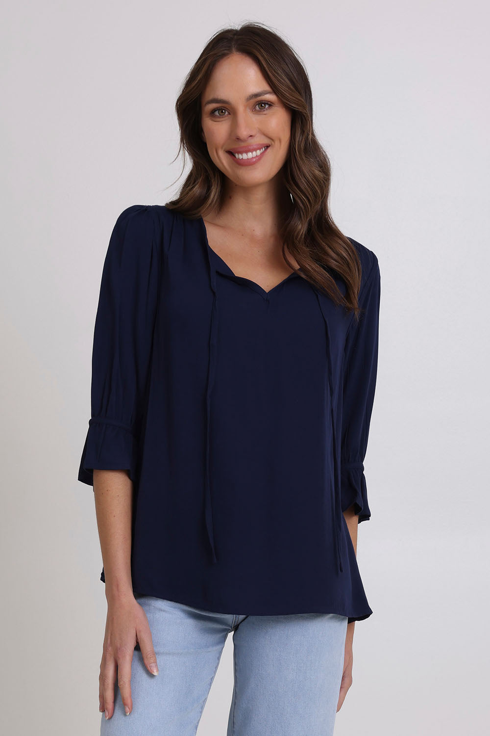 Model Madeline wearing size 10 of the Floriana Core Top in colour Navy (Blue), from the front, cropped image