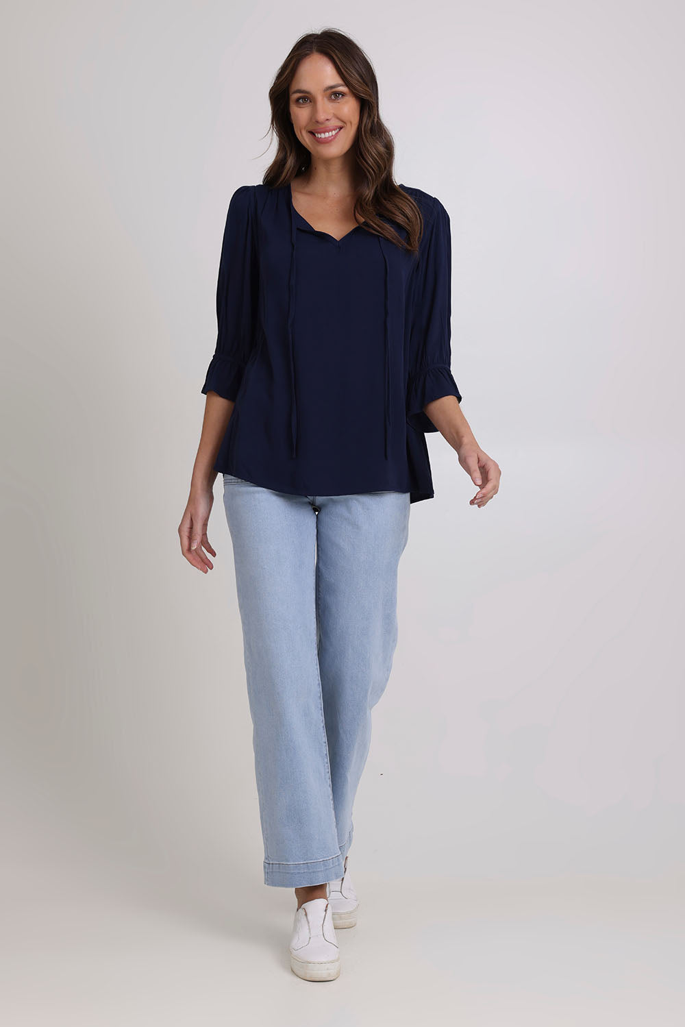 Model Madeline wearing size 10 of the Floriana Core Top in colour Navy (Blue), from the front, showing the whole outfit