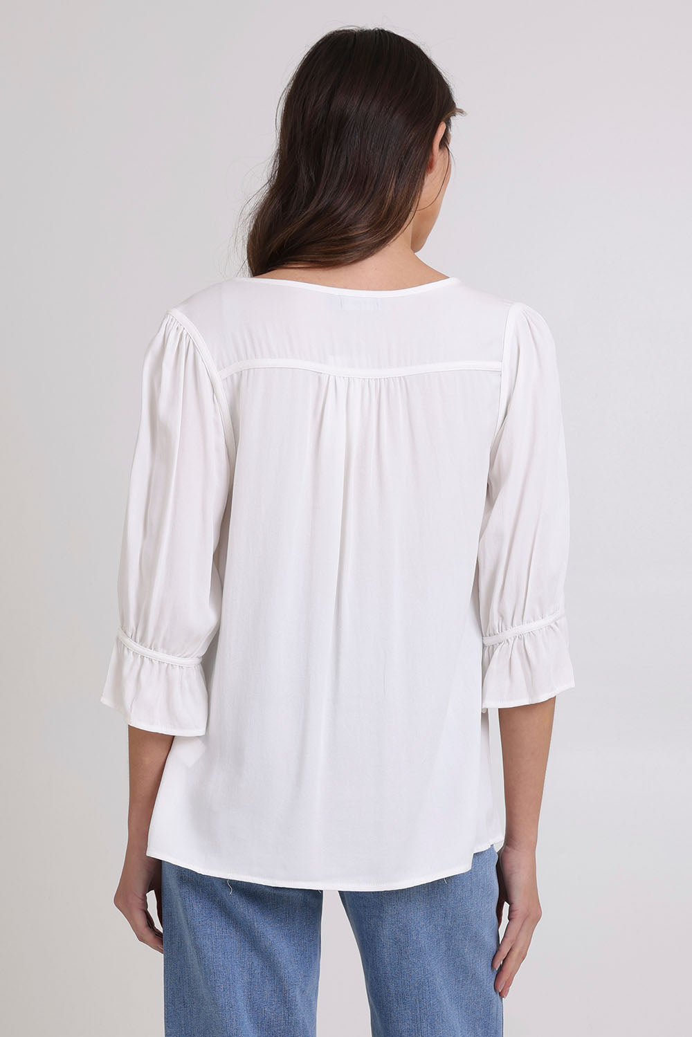 Model Madeline wearing size 10 of the Floriana Core Top in colour White (White), from the back