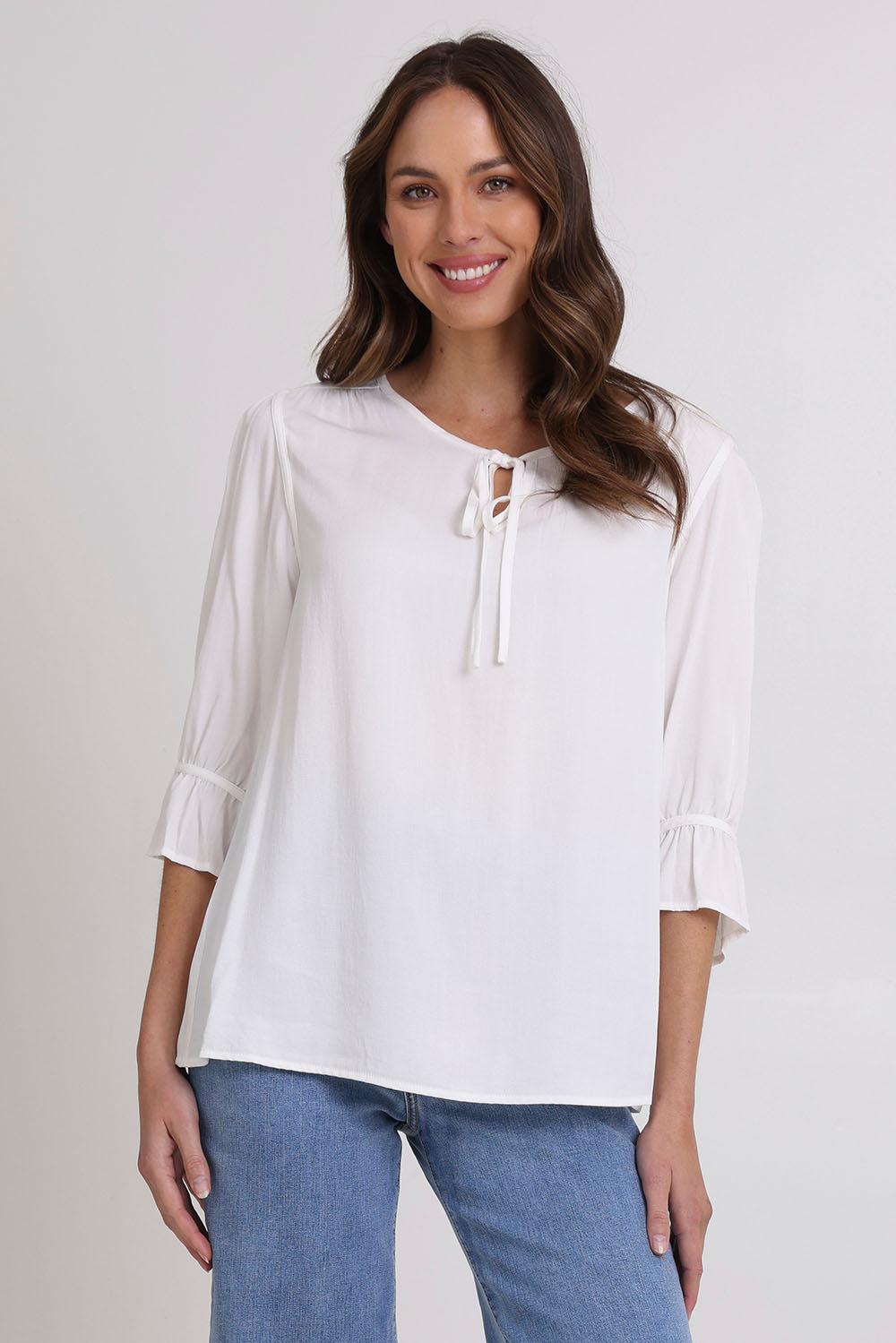 Model Madeline wearing size 10 of the Floriana Core Top in colour White (White), from the front, cropped image