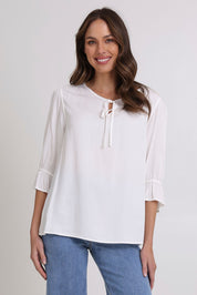 Model Madeline wearing size 10 of the Floriana Core Top in colour White (White), from the front, cropped image