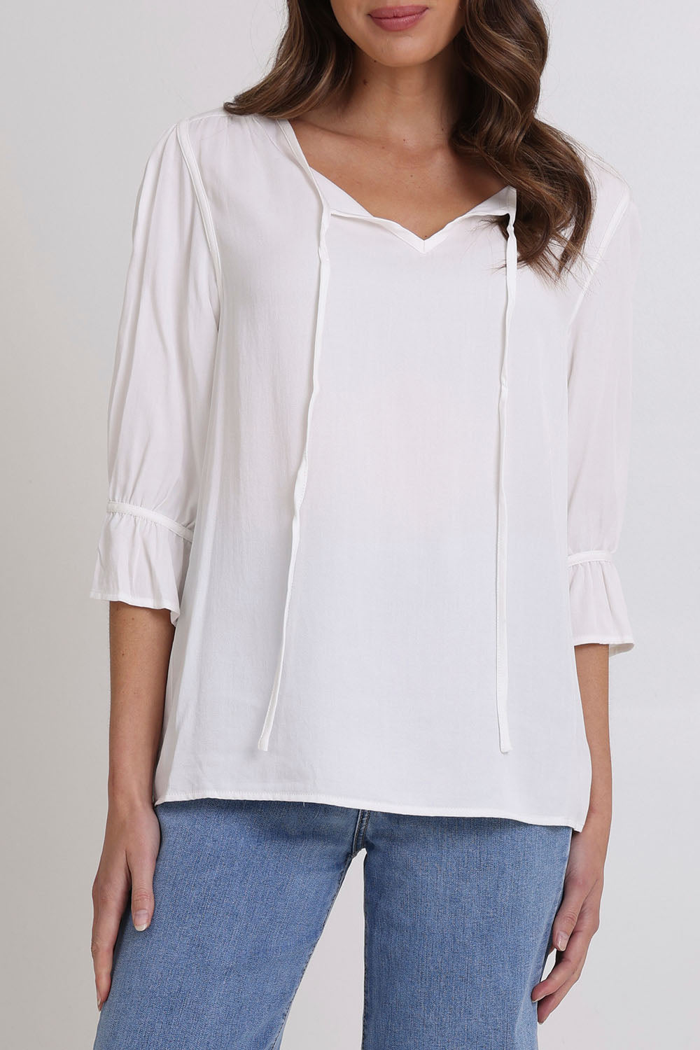 Model Madeline wearing size 10 of the Floriana Core Top in colour White (White), from the front, cropped image