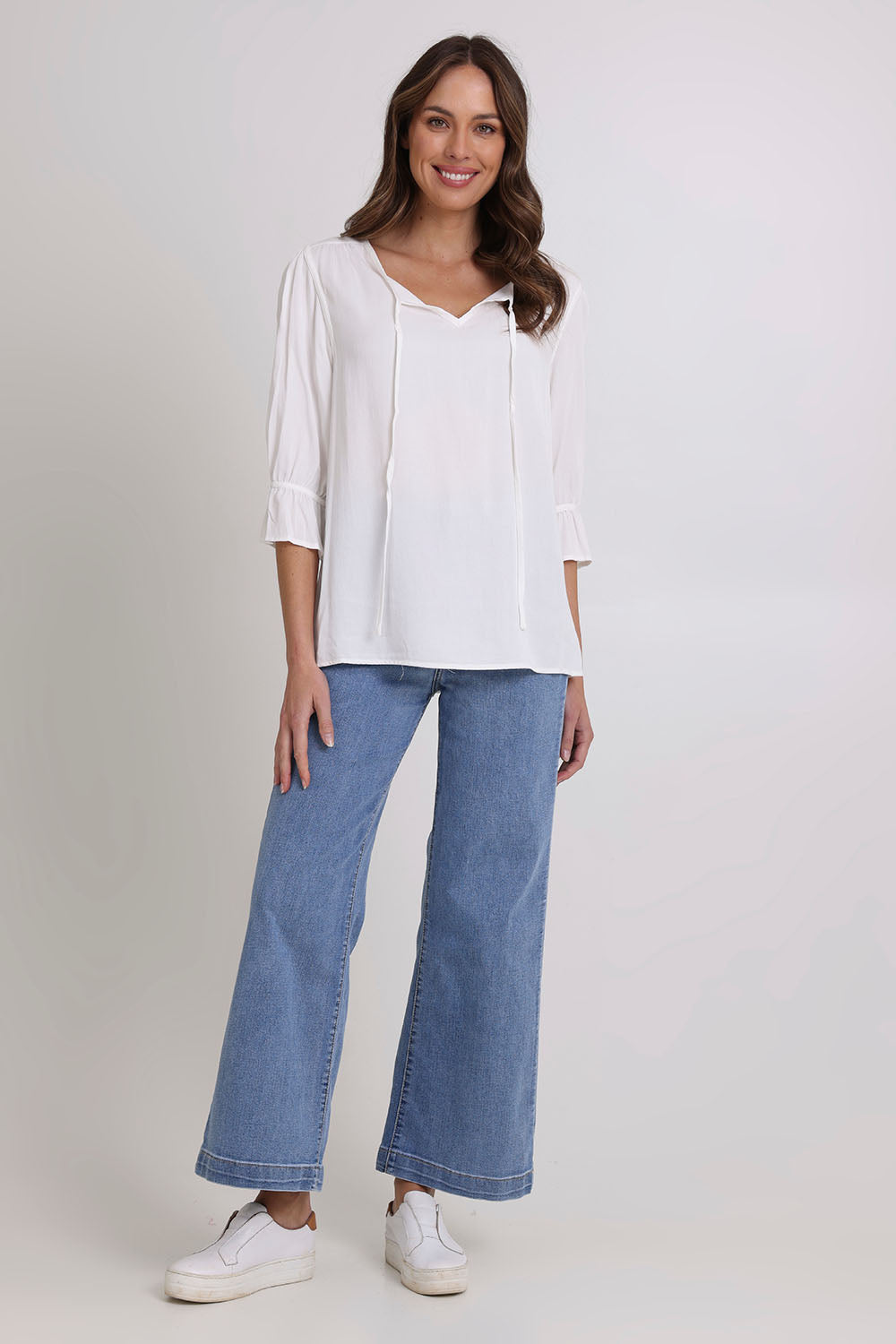 Model Madeline wearing size 10 of the Floriana Core Top in colour White (White), from the front, showing the whole outfit