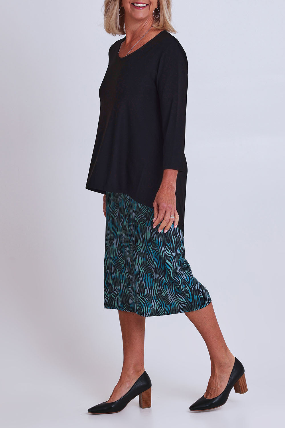 Model Sandy wearing size 10 of the Forgiveness Dress in colour Blackjade (Green), from the front, cropped image