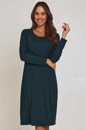 Model Madeline wearing size 10 of the Bamboo Dress in colour Forest (Green), from the front, cropped image