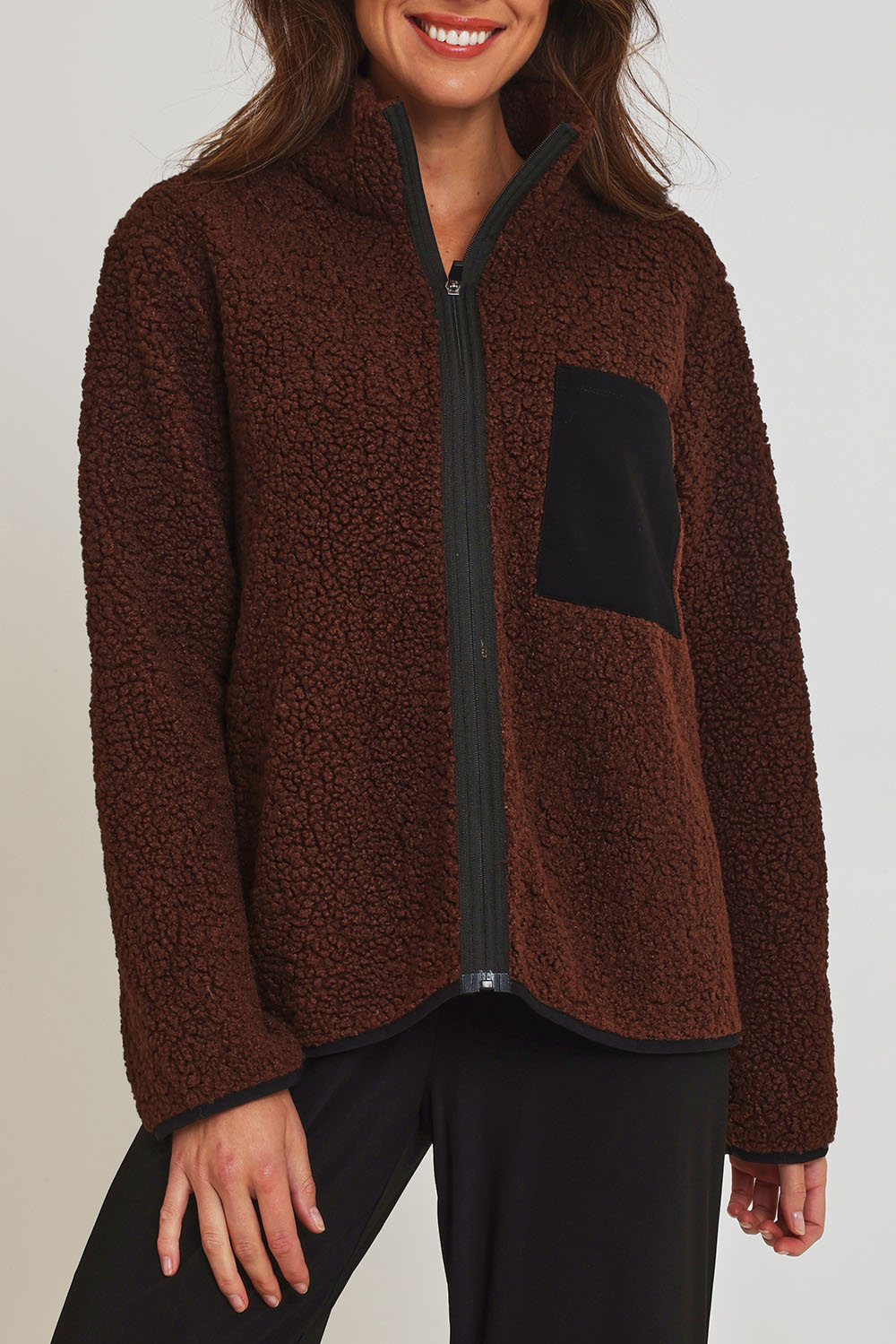 Model Madeline wearing size 10 of the Teddy Zippy Jacket in colour Choc, from the front, cropped image
