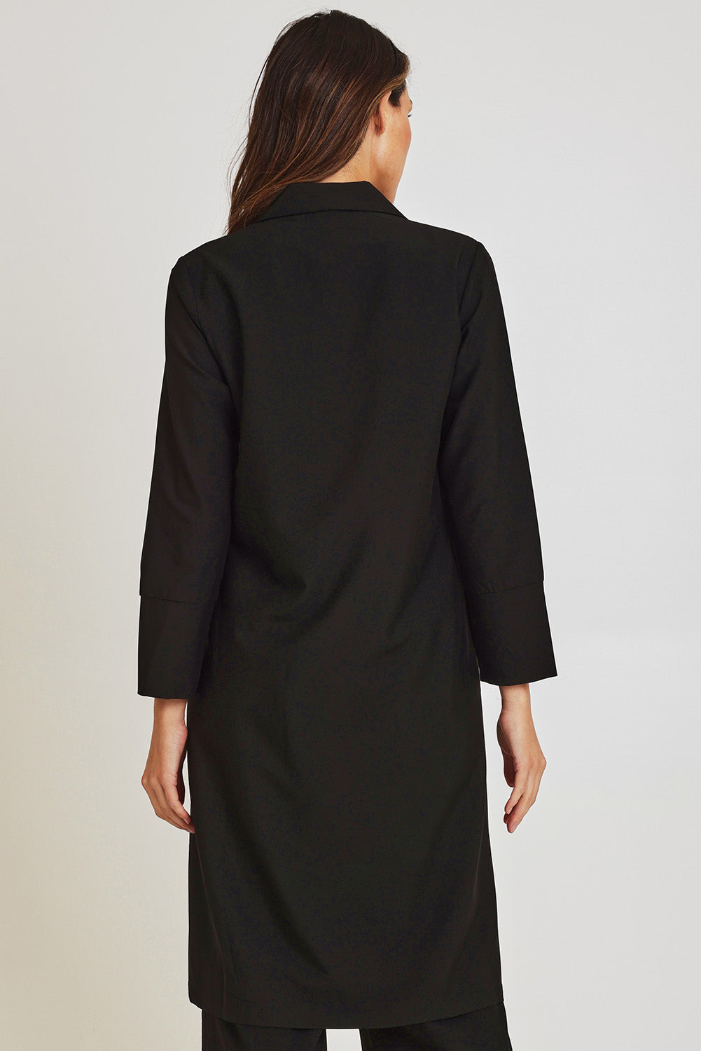 Model Madeline wearing size 10 of the Fluid Longline Jacket in colour Black (Black), from the back