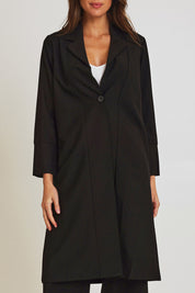 Model Madeline wearing size 10 of the Fluid Longline Jacket in colour Black (Black), from the front, cropped image