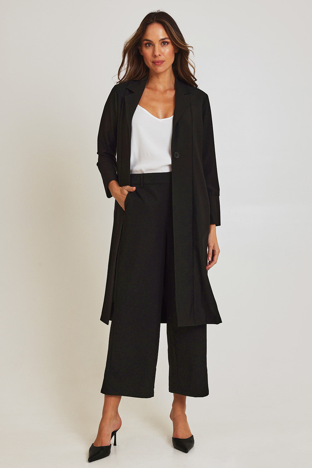 Model Madeline wearing size 10 of the Fluid Longline Jacket in colour Black (Black), from the front, showing the whole outfit