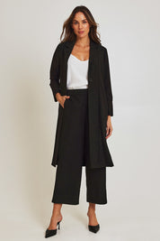 Model Madeline wearing size 10 of the Fluid Longline Jacket in colour Black (Black), from the front, showing the whole outfit