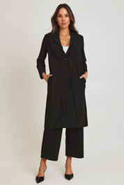 Model Madeline wearing size 10 of the Fluid Longline Jacket in colour Black (Black), from the front, showing the whole outfit