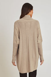 Model Madeline wearing the Polo Tunic Knit Jumper in colour Sand, from the back