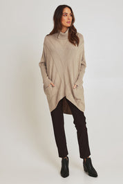 Model Madeline wearing the Polo Tunic Knit Jumper in colour Sand, from the front, showing the whole outfit