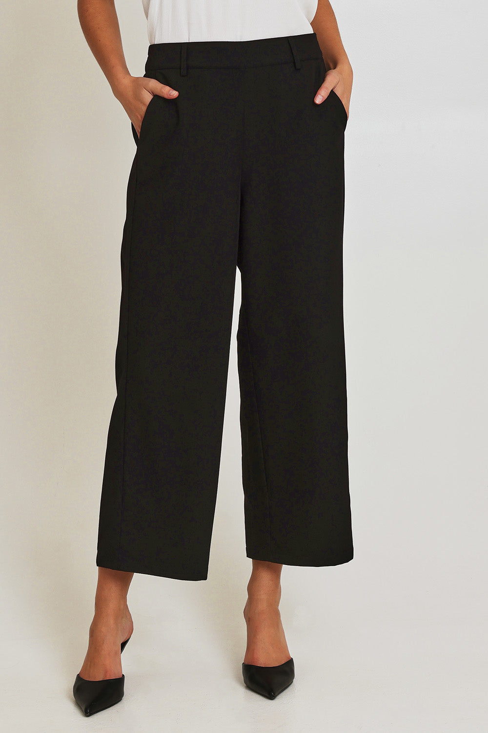 Model Madeline wearing size 10 of the Fluid Pocket Pant in colour Black (Black), from the front, cropped image