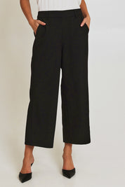 Model Madeline wearing size 10 of the Fluid Pocket Pant in colour Black (Black), from the front, cropped image