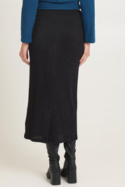 Model Madeline wearing size 10 of the Knit Core Skirt in colour Black (Black), from the back