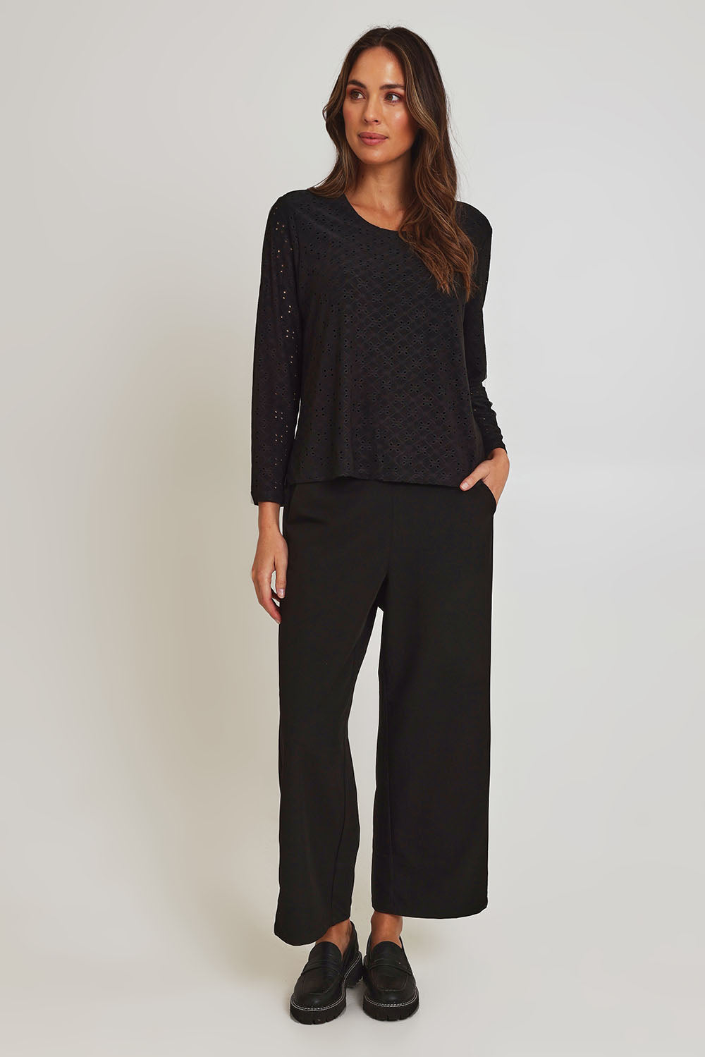 Model Madeline wearing size 10 of the Lace Broderie Top in colour Black (Black), from the front, showing the whole outfit