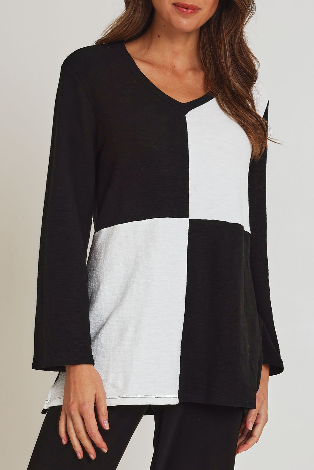 Model Madeline wearing size 10 of the Textured Splice Core Top in colour Blackivory (Black), from the front, cropped image