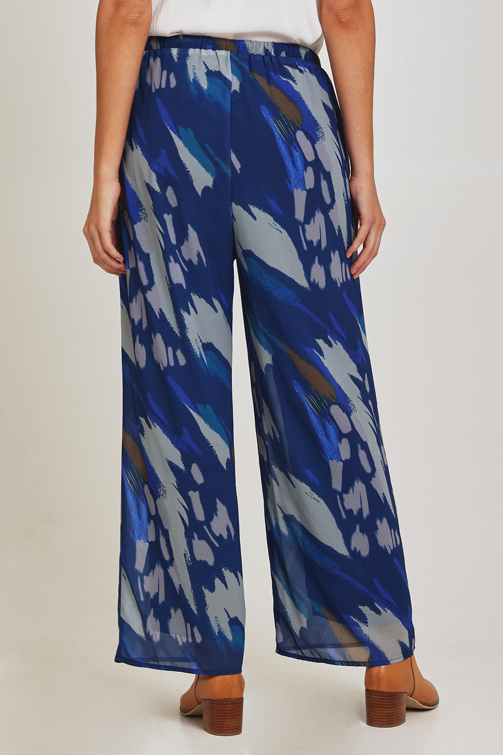 Model Madeline wearing size 10 of the Abstract Pant in colour Blueprint (Blue), from the back