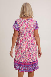 Model Sandy wearing size 10 of The Print Dress in colour Pink (Pink), from the back