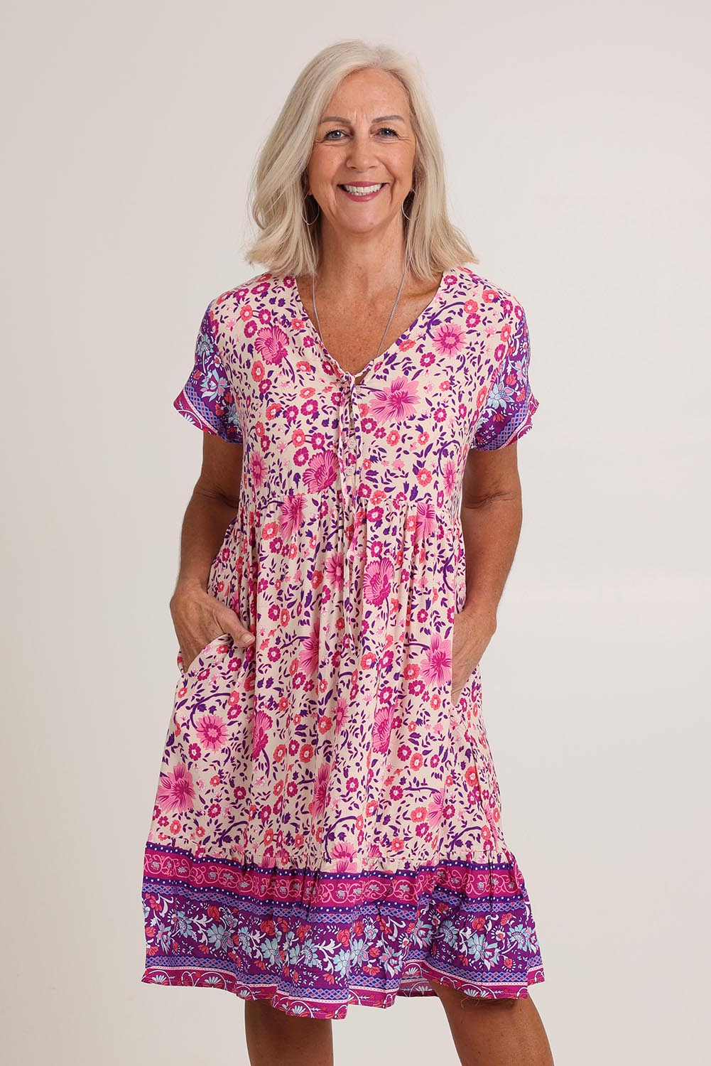 Model Sandy wearing size 10 of The Print Dress in colour Pink (Pink), from the front, cropped image