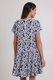 Model Madeline wearing size 10 of the Katina Tier Short Dress in colour Navy (Blue), from the back
