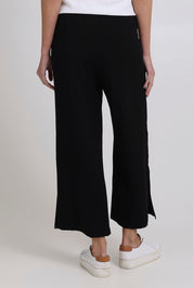Model Madeline wearing size 10 of the Linen Shores Pant in colour Black (Black), from the back
