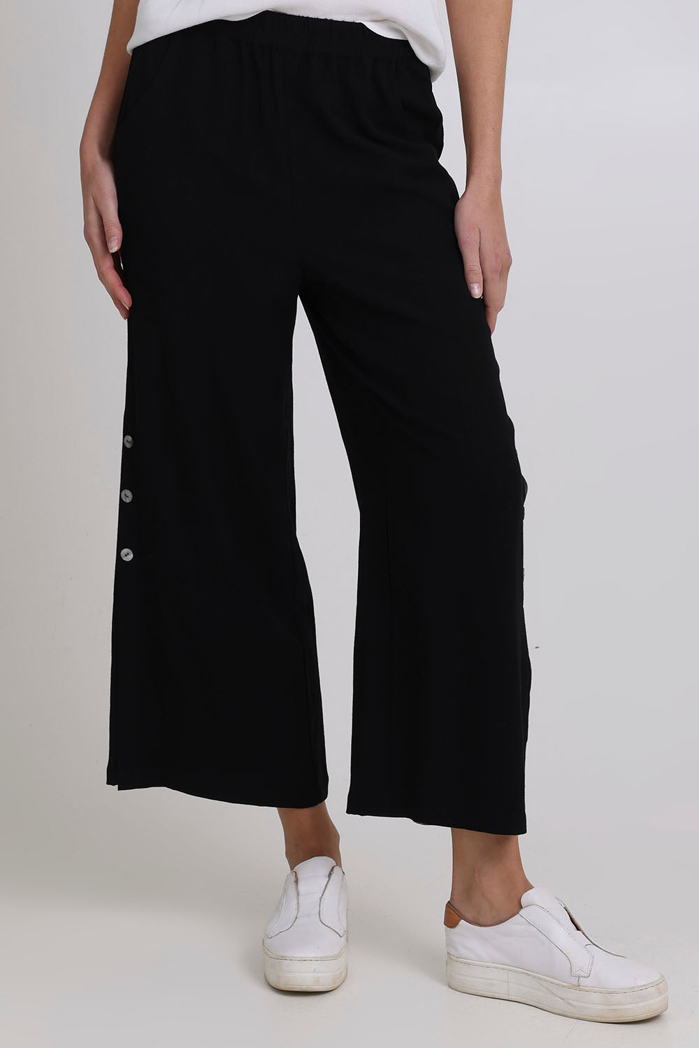 Model Madeline wearing size 10 of the Linen Shores Pant in colour Black (Black), from the front, cropped image
