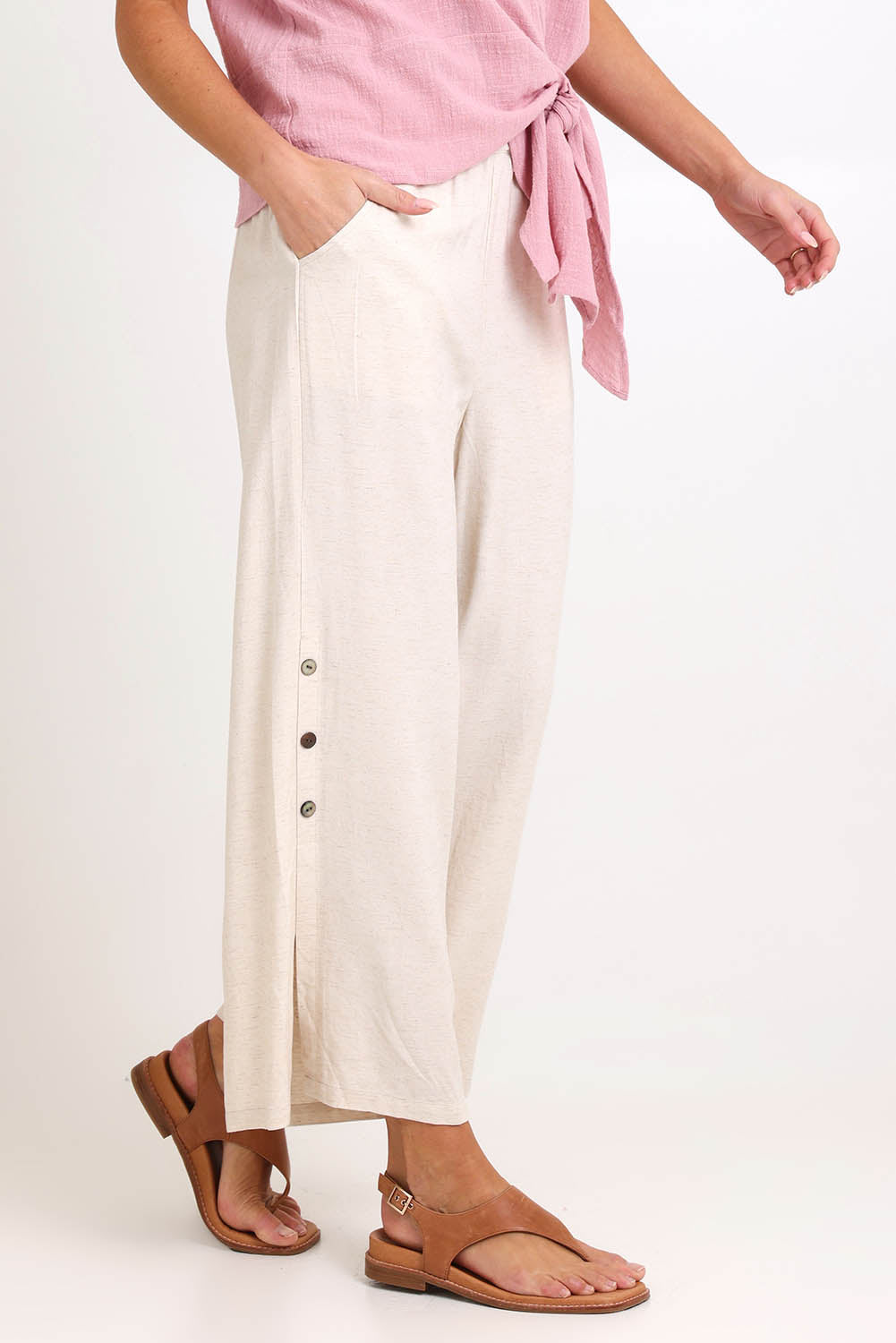 Model Madelinec wearing size 10 of the Linen Shores Pant – Sand in colour Sand, from an angle