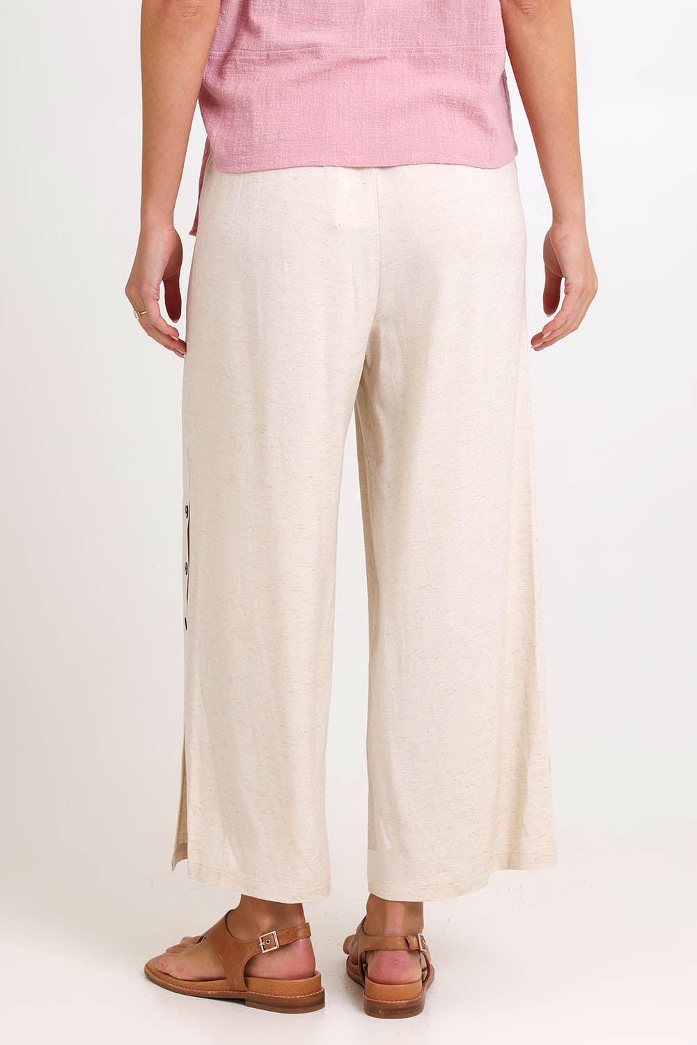 Model Madelinec wearing size 10 of the Linen Shores Pant – Sand in colour Sand, from the back