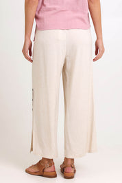 Model Madelinec wearing size 10 of the Linen Shores Pant – Sand in colour Sand, from the back