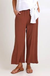 Model Madelinec wearing size 10 of the Linen Shores Pant – Toffee in colour Toffee, in a cropped view
