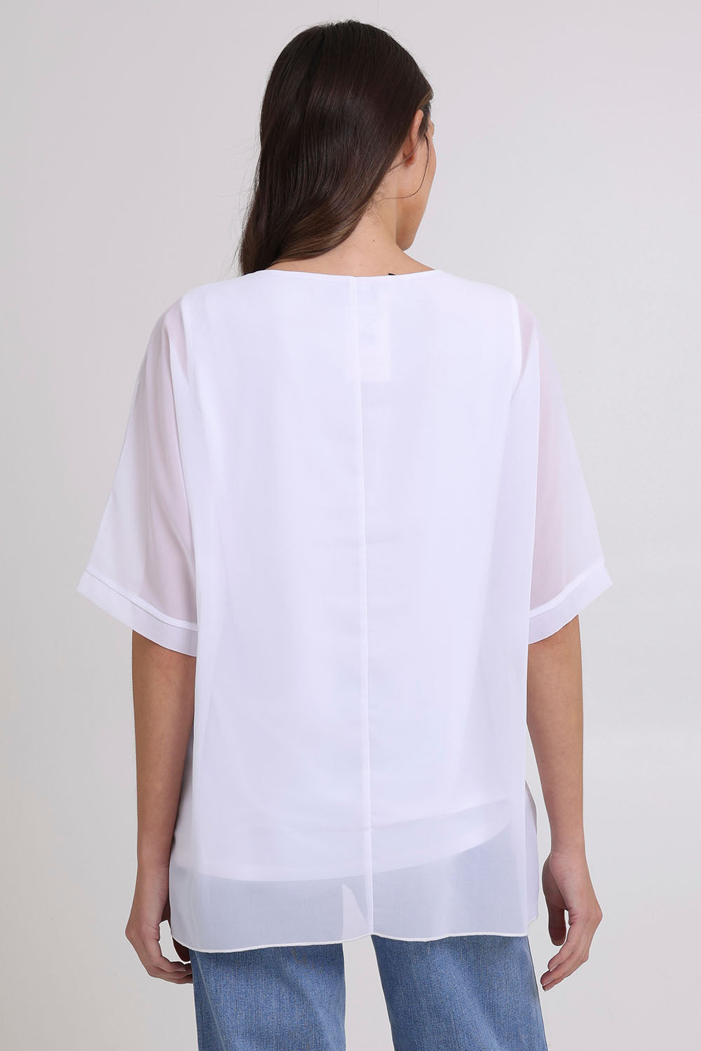 Model Madeline wearing size 10 of the Gilliana Chiffon Overlay Top in colour White (White), from the back