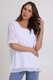Model Madeline wearing size 10 of the Gilliana Chiffon Overlay Top in colour White (White), from the front, cropped image