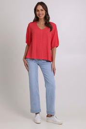 Model Madeline wearing size 10 of the Victoria Textured Cotton Blend Top in colour Coral (Pink), from the front, showing the whole outfit