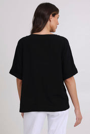 Model Madeline wearing size 10 of the Linen Shores Top in colour Black (Black), from the back