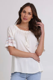 Model Madeline wearing size 10 of the Oakley Embroidered Top in colour Ivory (White), from the front, cropped image