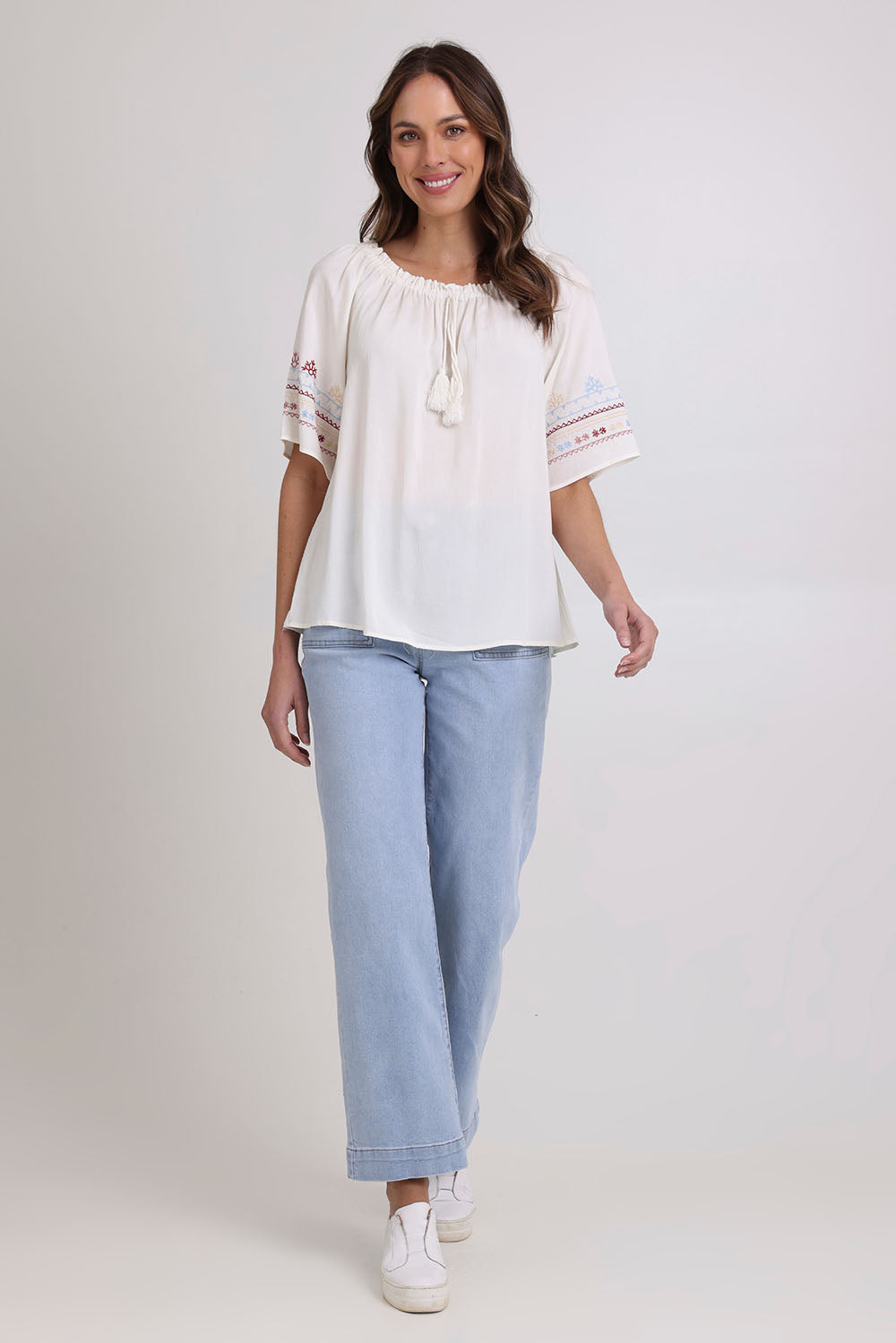 Model Madeline wearing size 10 of the Oakley Embroidered Top in colour Ivory (White), from the front, showing the whole outfit