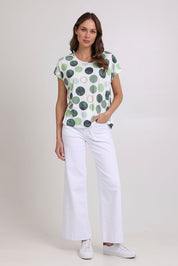 Model Madeline wearing size 10 of the Spotty Dotty Cap Sleeve Top in colour Whitegrn (Green), from the front, showing the whole outfit