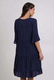 Model Madeline wearing size 10 of the Jessie Dress in colour Navy (Blue), from the back