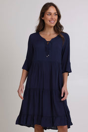 Model Madeline wearing size 10 of the Jessie Dress in colour Navy (Blue), from the front, cropped image