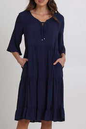 Model Madeline wearing size 10 of the Jessie Dress in colour Navy (Blue), from the front, cropped image