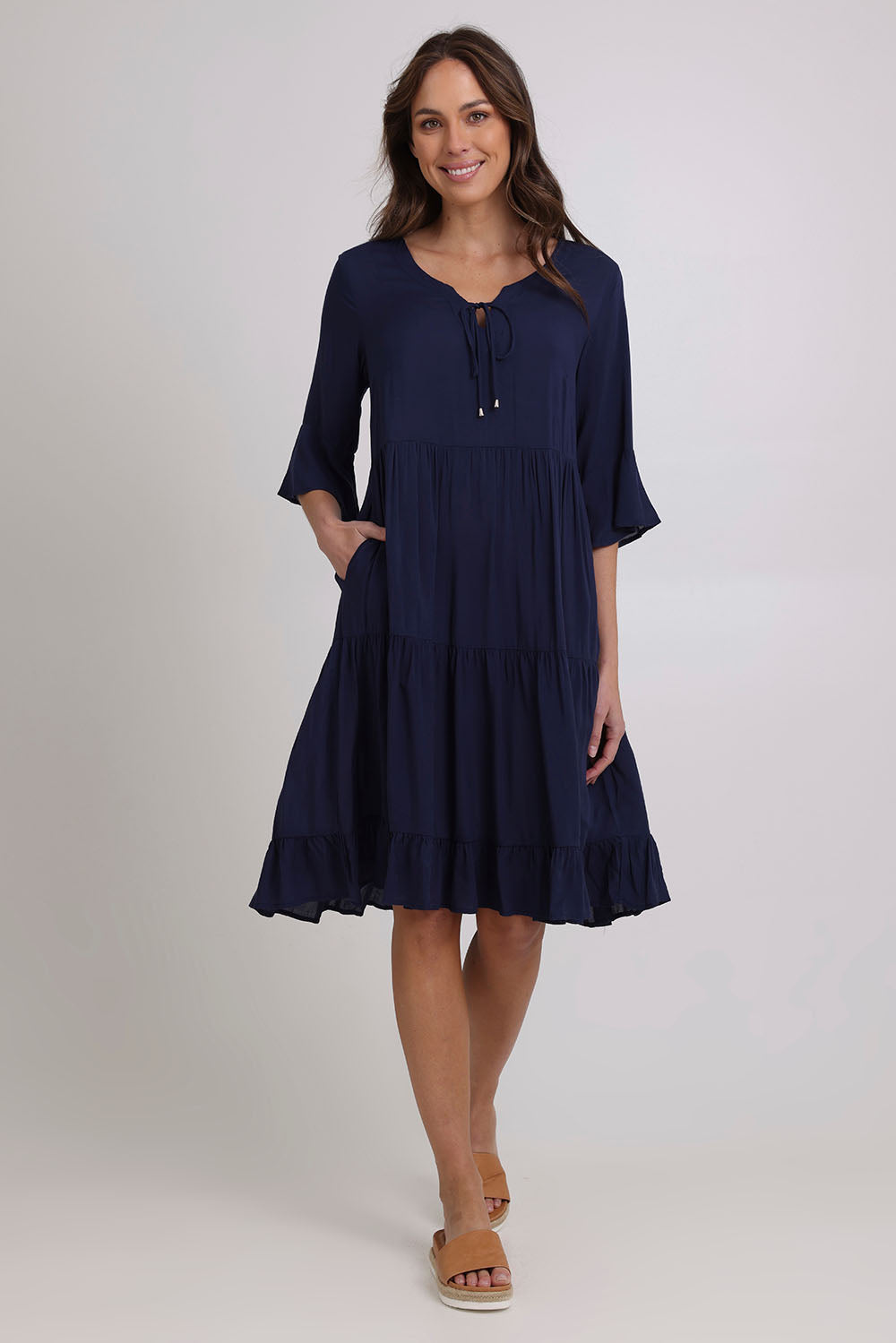 Model Madeline wearing size 10 of the Jessie Dress in colour Navy (Blue), from the front, showing the whole outfit