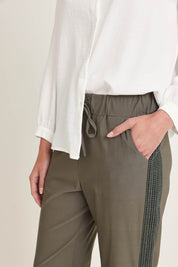 Model Madeline wearing size 10 of the Stretch Jeanie Pant in colour Khaki (Green), from the front, cropped image