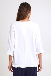Model Madelinec wearing size 10 of the Ruffle Top – White in colour White, from the back