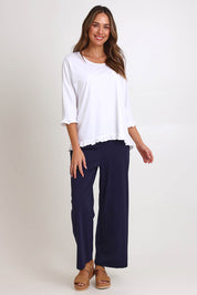 Model Madelinec wearing size 10 of the Ruffle Top – White in colour White, from the front